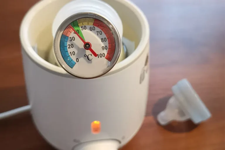 Babyflasche im Flaschenwärmer mit Thermometer zur Temperaturkontrolle