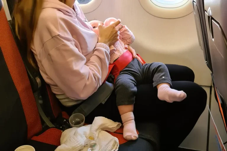 Mutter gibt ihrem Baby im Flugzeug das Fläschchen