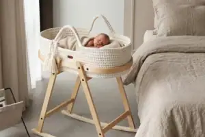 Neugeborenes schläft im gehäkelten Moseskorb auf der LIINI Babywiege